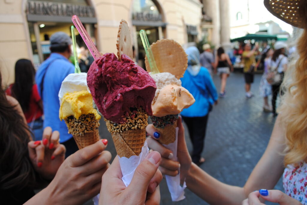 Three people holding ice cream in the centre of Rome